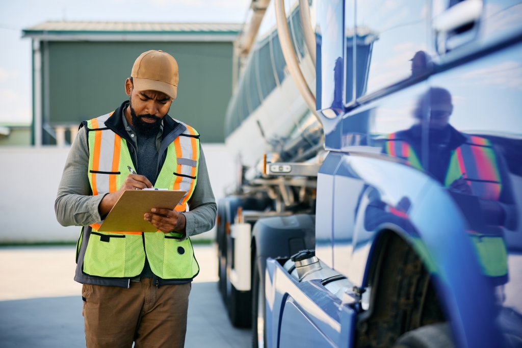 transportation manager taking notes while going through checklist on parking lot.